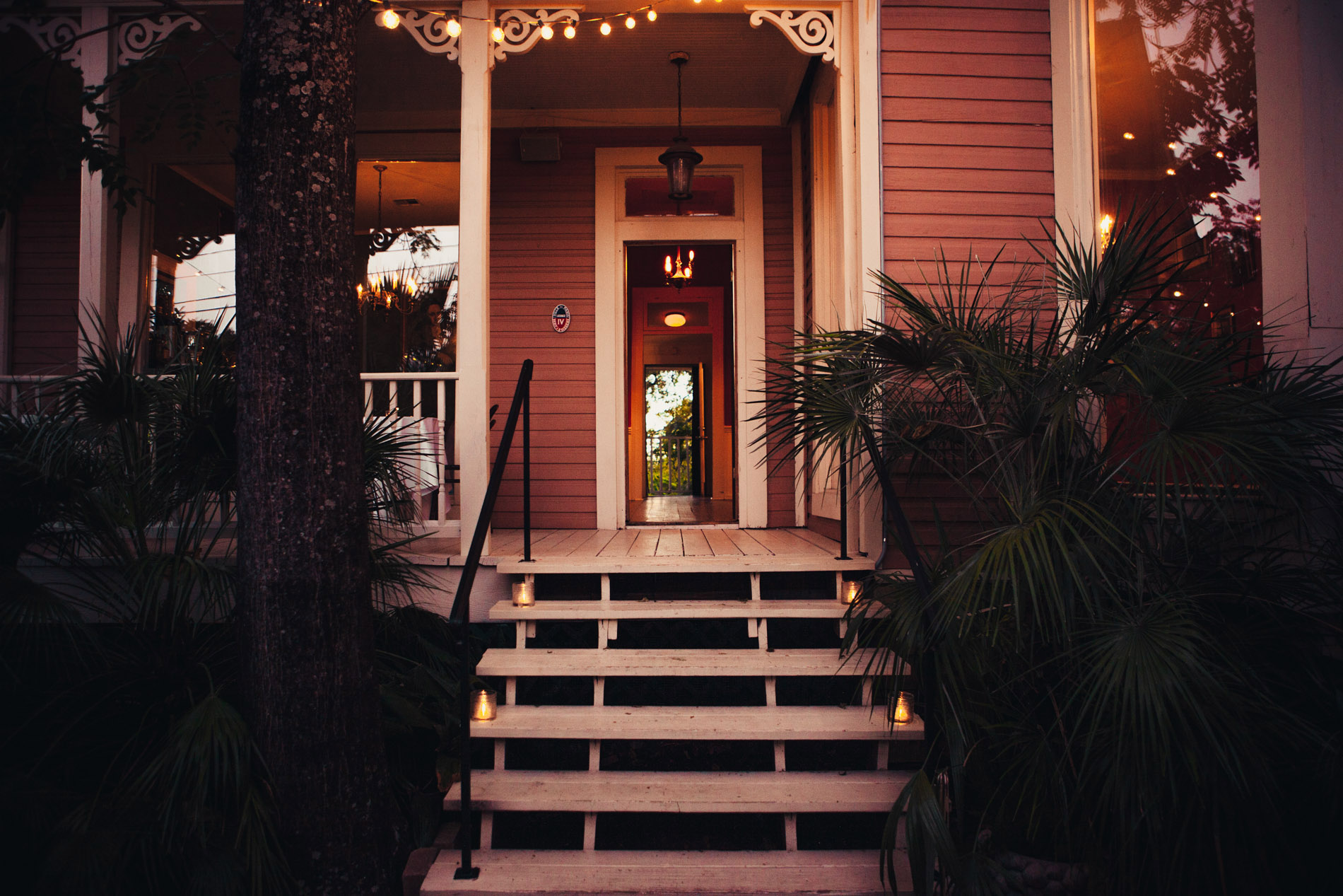 The candlelit front porch and entrance of Justine’s Secret House