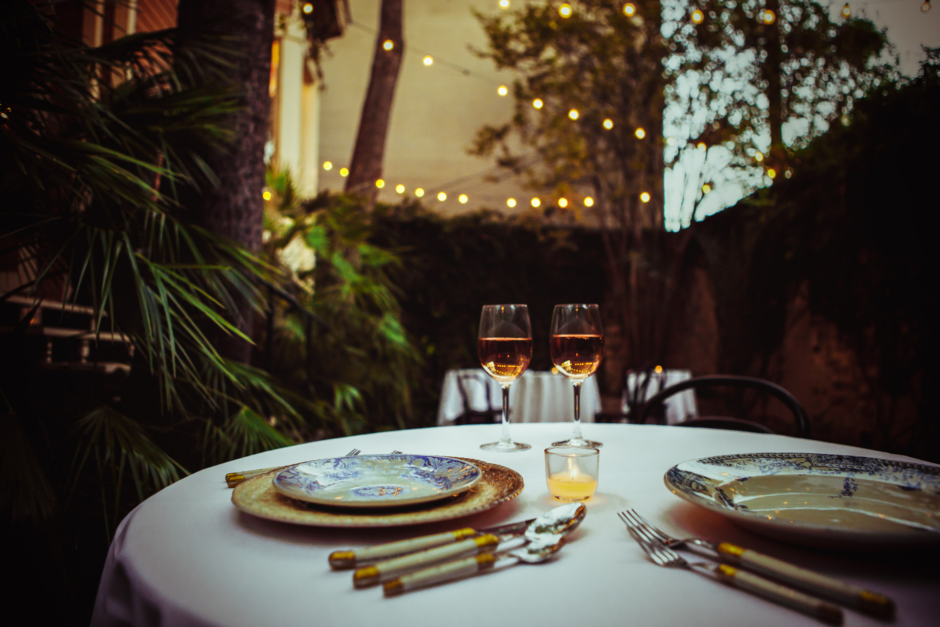 A candlelit table for two beneath the garden lights at Justine’s Secret House